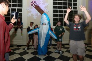 Students dancing with person in inflatable shark costume__photo by Paola Nogueras