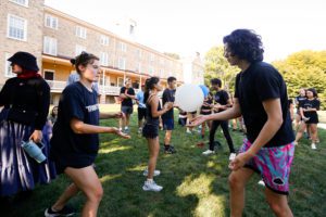 Two students keeping a white balloon afloat_photo by Paola Nogueras