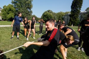 student in black t-shirt pulling on rope during Dorm Olympics tug of war_photo by Paola Nogueras