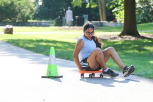 Student rolling on scooter during Dorm Olympics challenge_photo by Paola Nogueras