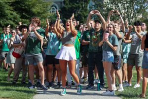 Group of students in green cheering_photo by Paola Nogueras