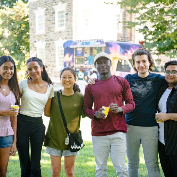 Six people posing for a photo outside