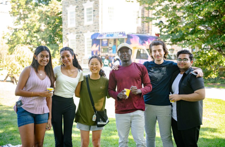 Six people posing for a photo outside