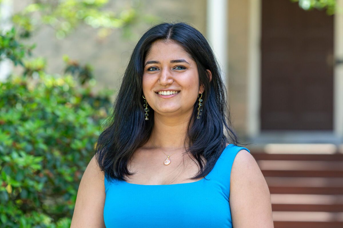 Bela Khanna wears a blue outfit and is pictured against one of Haverford's historic buildings.