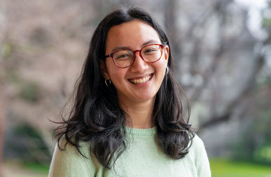 In a portrait, Elena Bien wears glasses and a light green sweater.