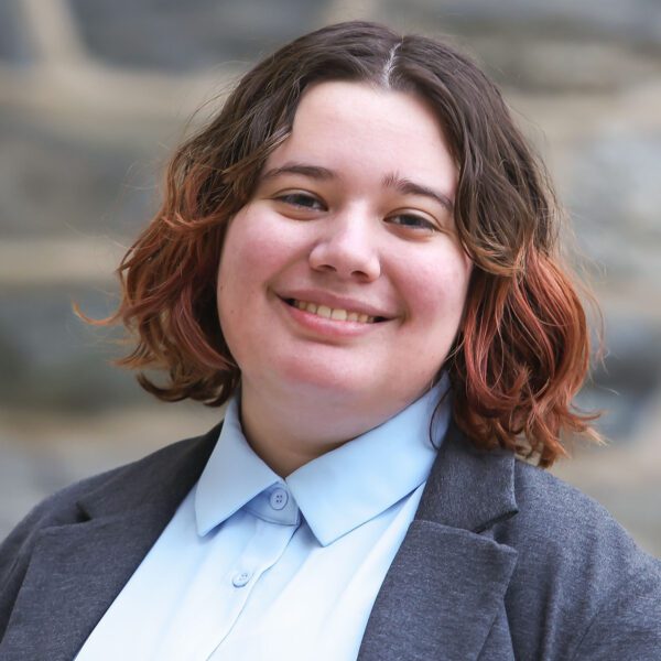 Juno Bartsch is pictured against a stone wall in a portrait taken on Haverford's campus.