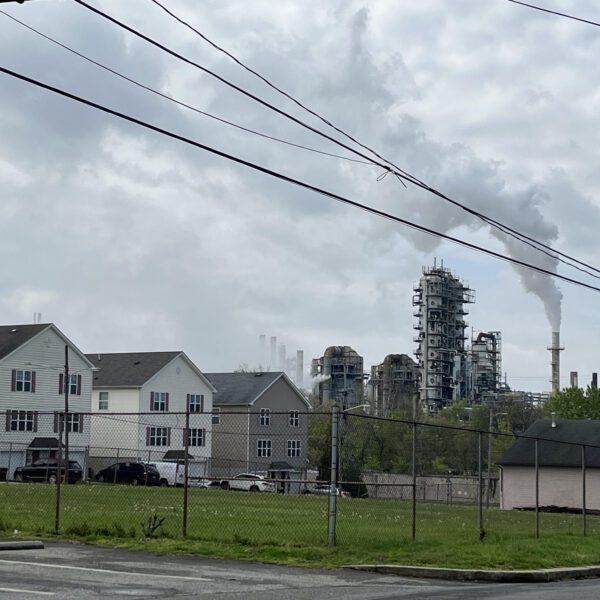 Billowing smokestacks from a refinery in Chester, Pennsylvania, abut several houses.