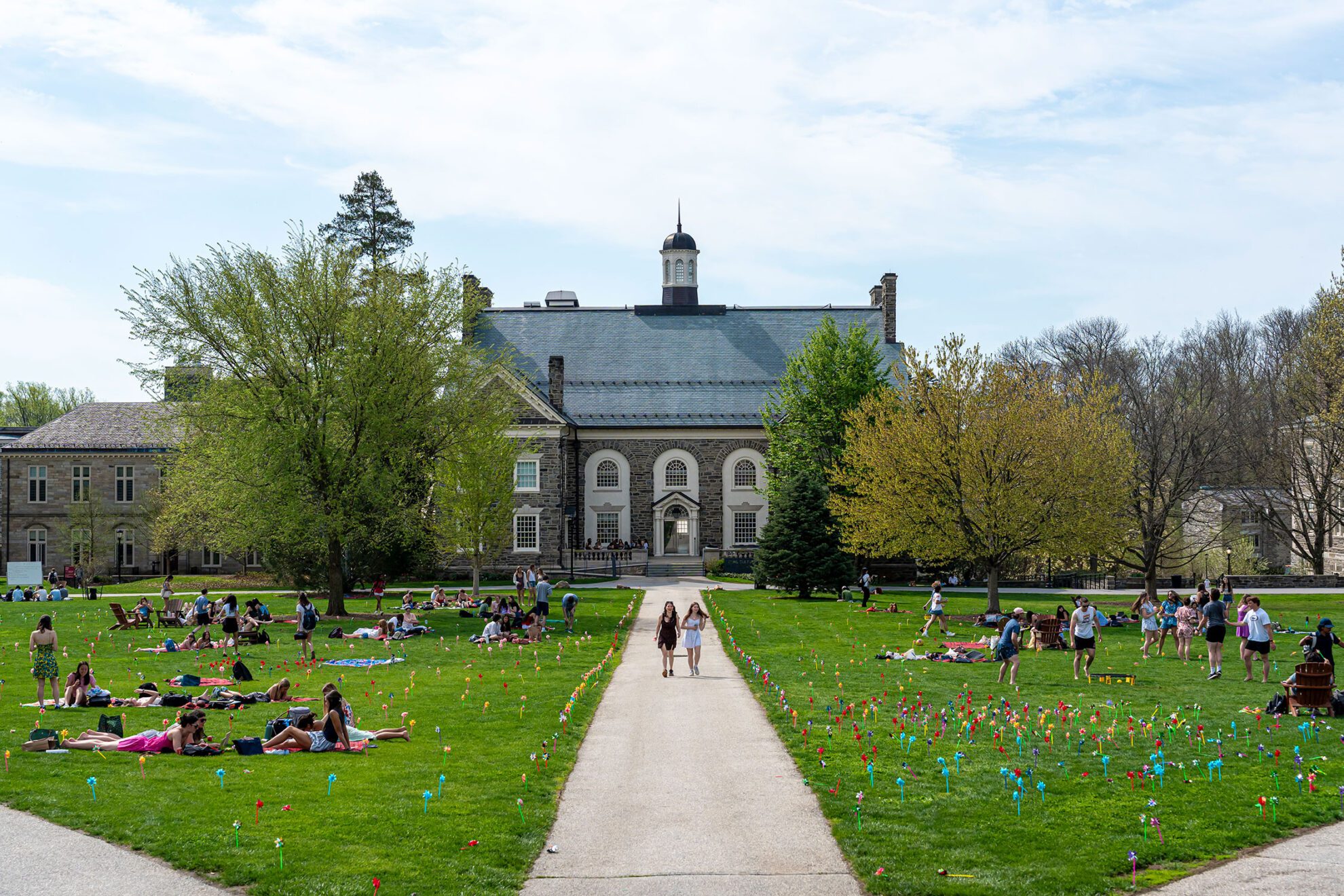 A wide view of campus shows students spread across the lawn for Pinwheel Day, with colorful pinwheels lining the walkways.