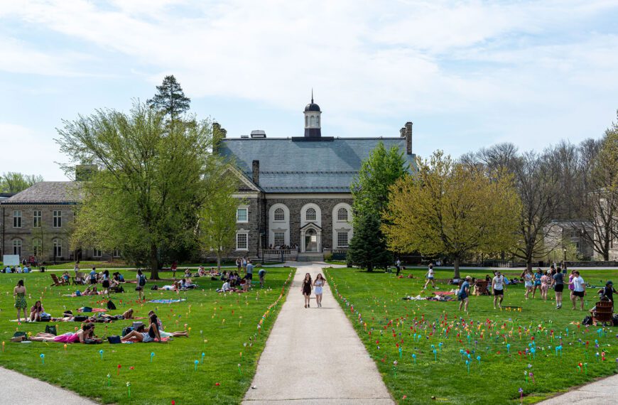 A wide view of campus shows students spread across the lawn for Pinwheel Day, with colorful pinwheels lining the walkways.