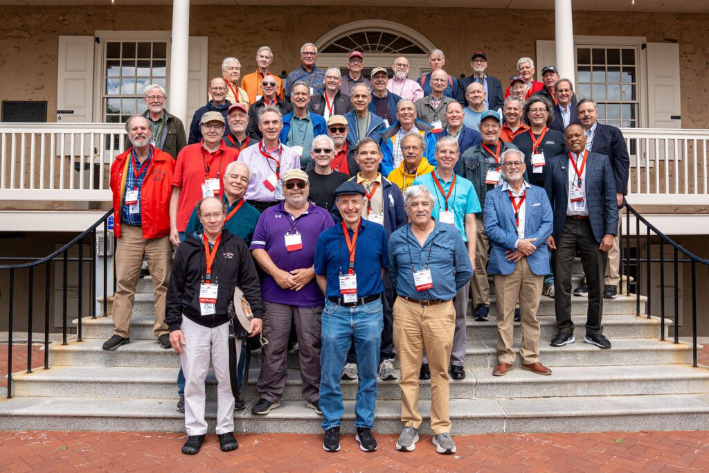 Members of the Class of 1976 pose together on the steps outside a campus building during their reunion.